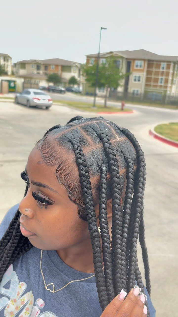 20 Braids and Women Hairstyles to Try in 2026 2 Woman with long black knotless braids posing outdoors in a residential neighborhood.