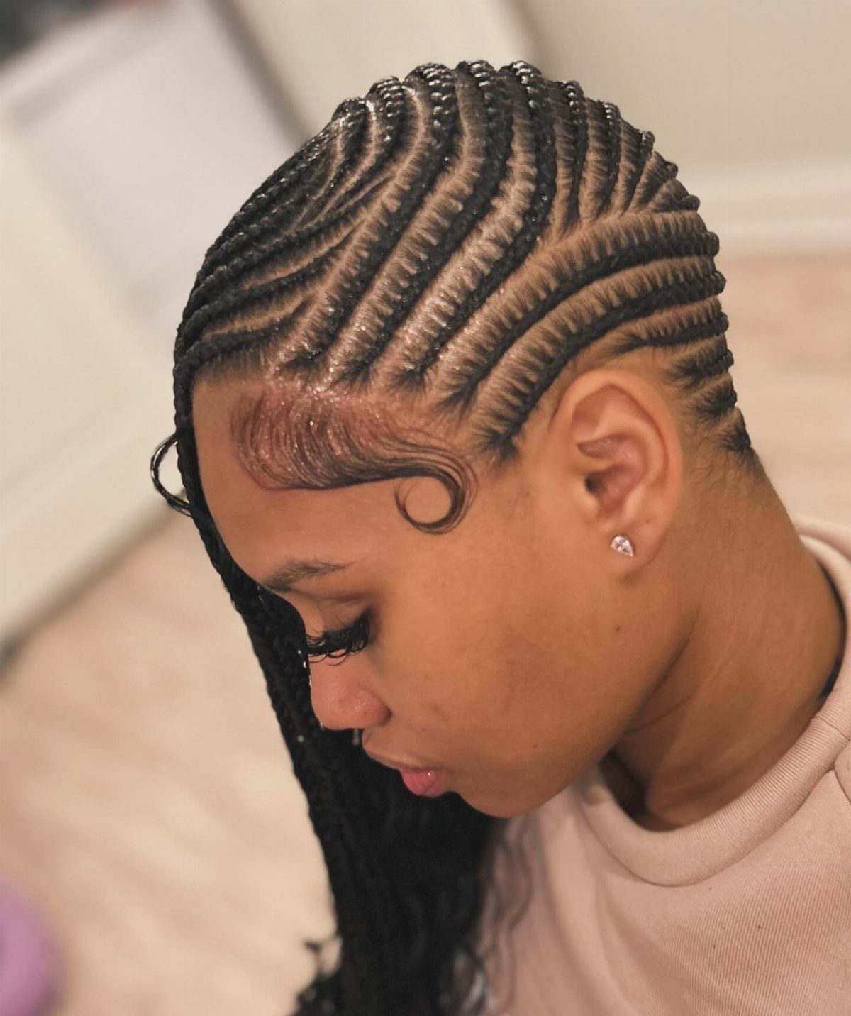 20 Braids and Women Hairstyles to Try in 2026 19 Woman with side-parted cornrows styled in lemonade braids, viewed from the side profile.