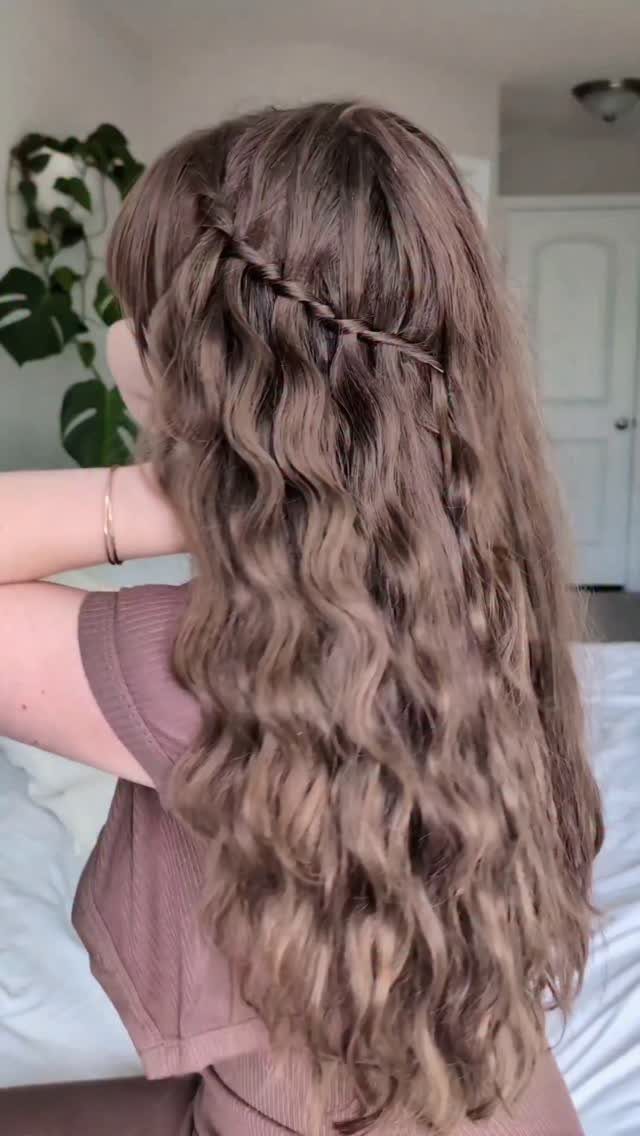 20 Braids and Women Hairstyles to Try in 2026 12 Woman with long wavy brown hair featuring a horizontal waterfall braid hairstyle.