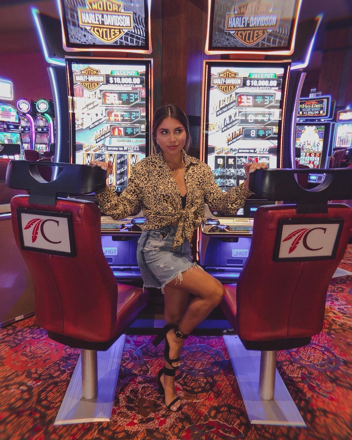 Woman in leopard print blouse and denim shorts posing in a casino.