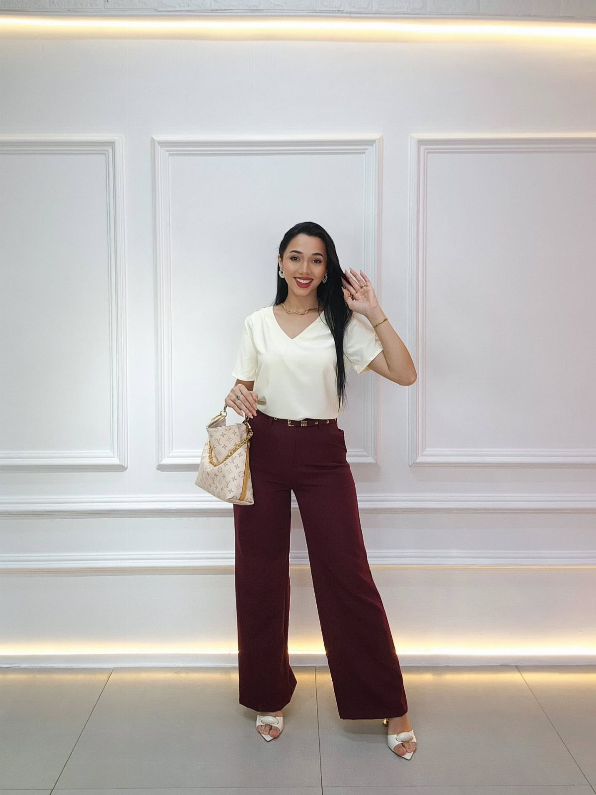 Woman wearing a white fitted top and burgundy wide-leg palazzo pants with heels.