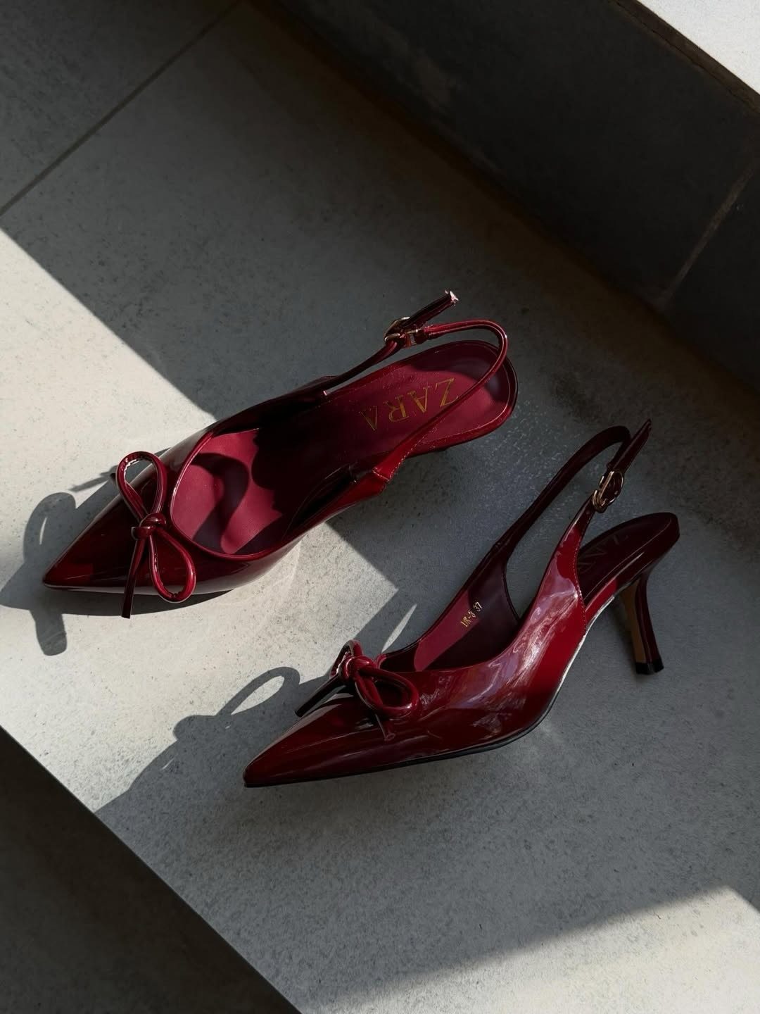 Cherry Red Kitten Heels: 6 Ideas from Straps to Buckles 2 Cherry red kitten heels with bows and slingback straps on a grey stone surface.