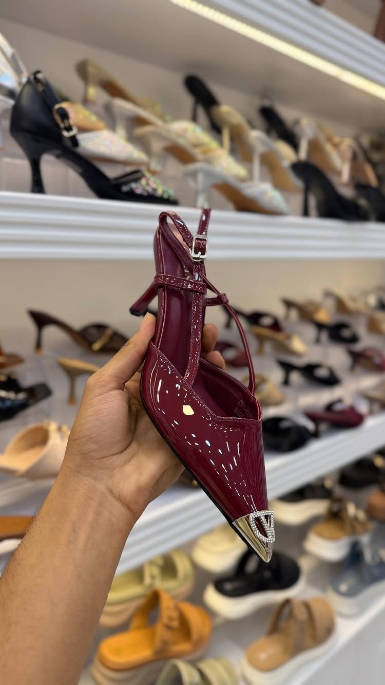 Cherry Red Kitten Heels: 6 Ideas from Straps to Buckles 6 Cherry red patent leather kitten heel with silver buckle held in a hand