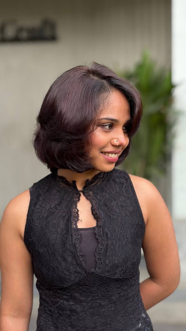 Chocolate Plum Hair: 6 Ideas for Deep Purple-Brown Color 6 Woman with a deep plum-brown layered bob haircut wearing a black lace dress.