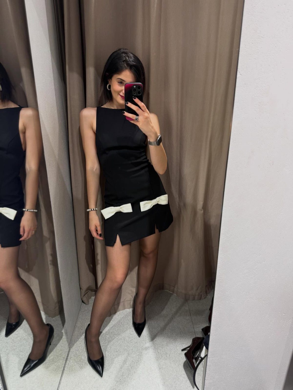 Christmas Outfit for Work: 13 Ideas to Wear to the Office 12 Woman in a black cocktail dress with white bow and black heels.