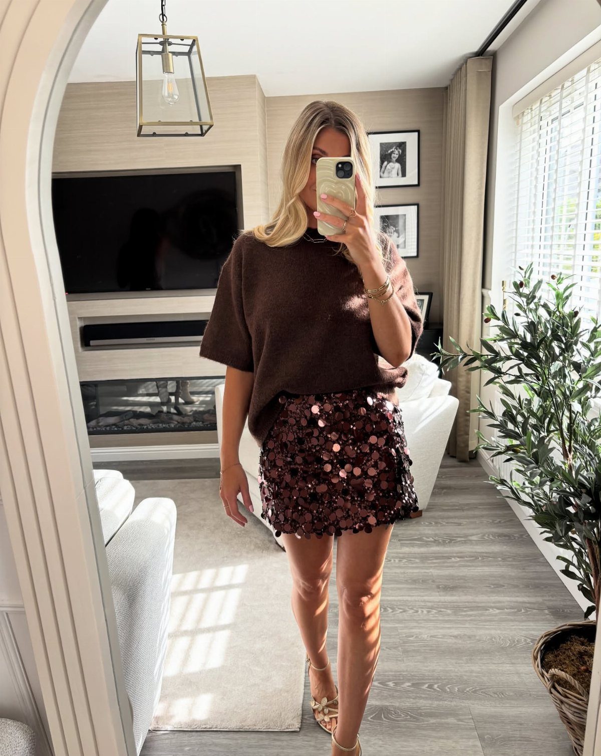 Christmas Outfit for Work: 13 Ideas to Wear to the Office 1 Woman wearing a brown sweater and a dark red sequin mini skirt.