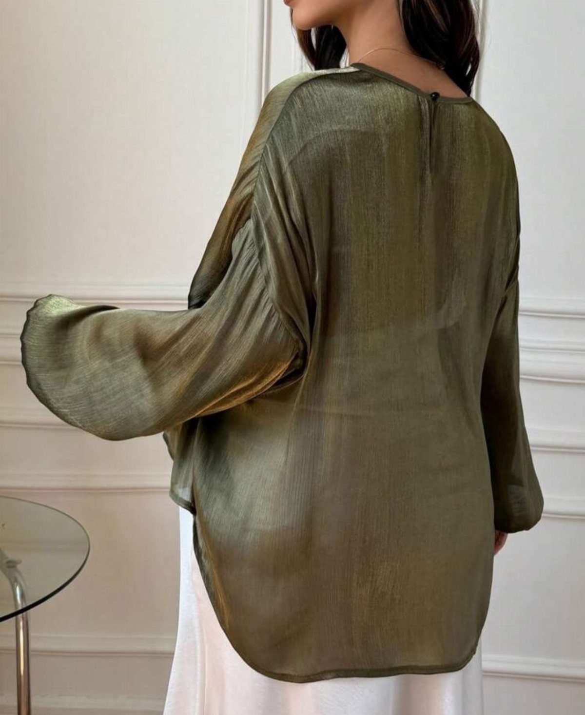 Christmas Outfit for Work: 13 Ideas to Wear to the Office 13 Woman wearing an olive green shimmering blouse and white skirt in a bright room.