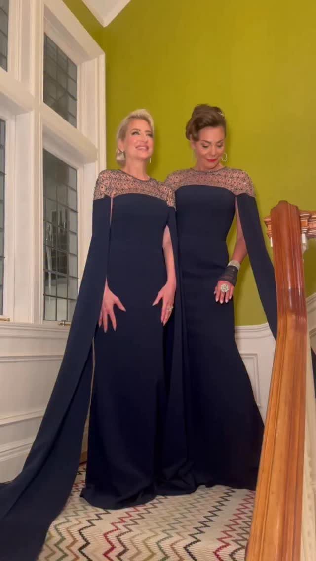 Classic Formal Gowns: 8 Styles for Evening Events 8 Two women wearing matching navy blue floor-length formal gowns with lace shoulder details.