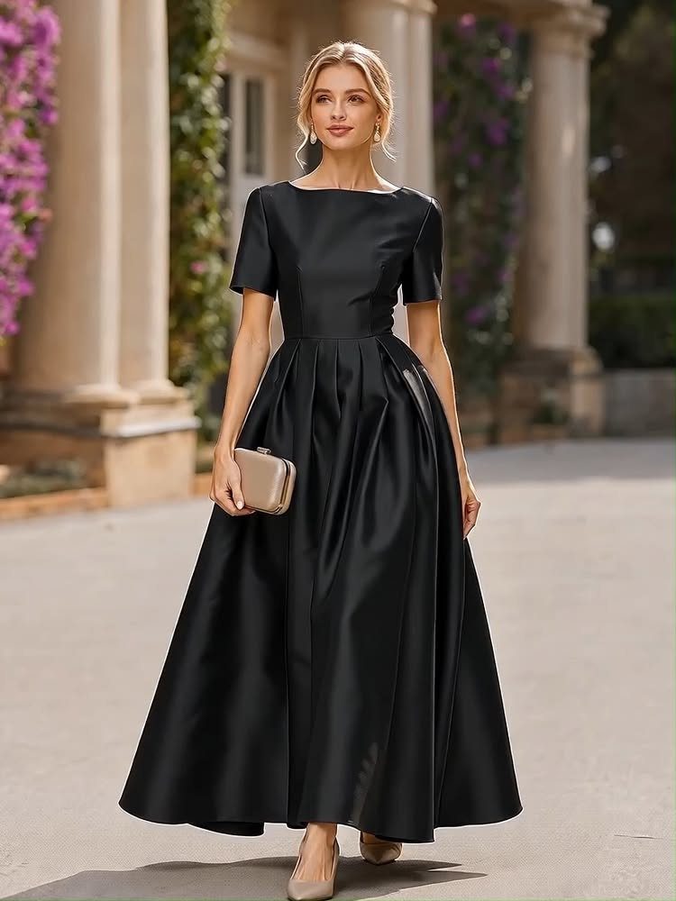 Classic Formal Gowns: 8 Styles for Evening Events 1 Woman in a classic black floor-length satin formal gown holding a beige clutch.