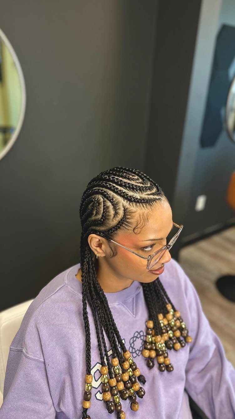 Cornrows and Twists Hairstyles: 11 Ideas to Try 2 Woman with cornrow braids featuring decorative brown and gold beads at the ends.