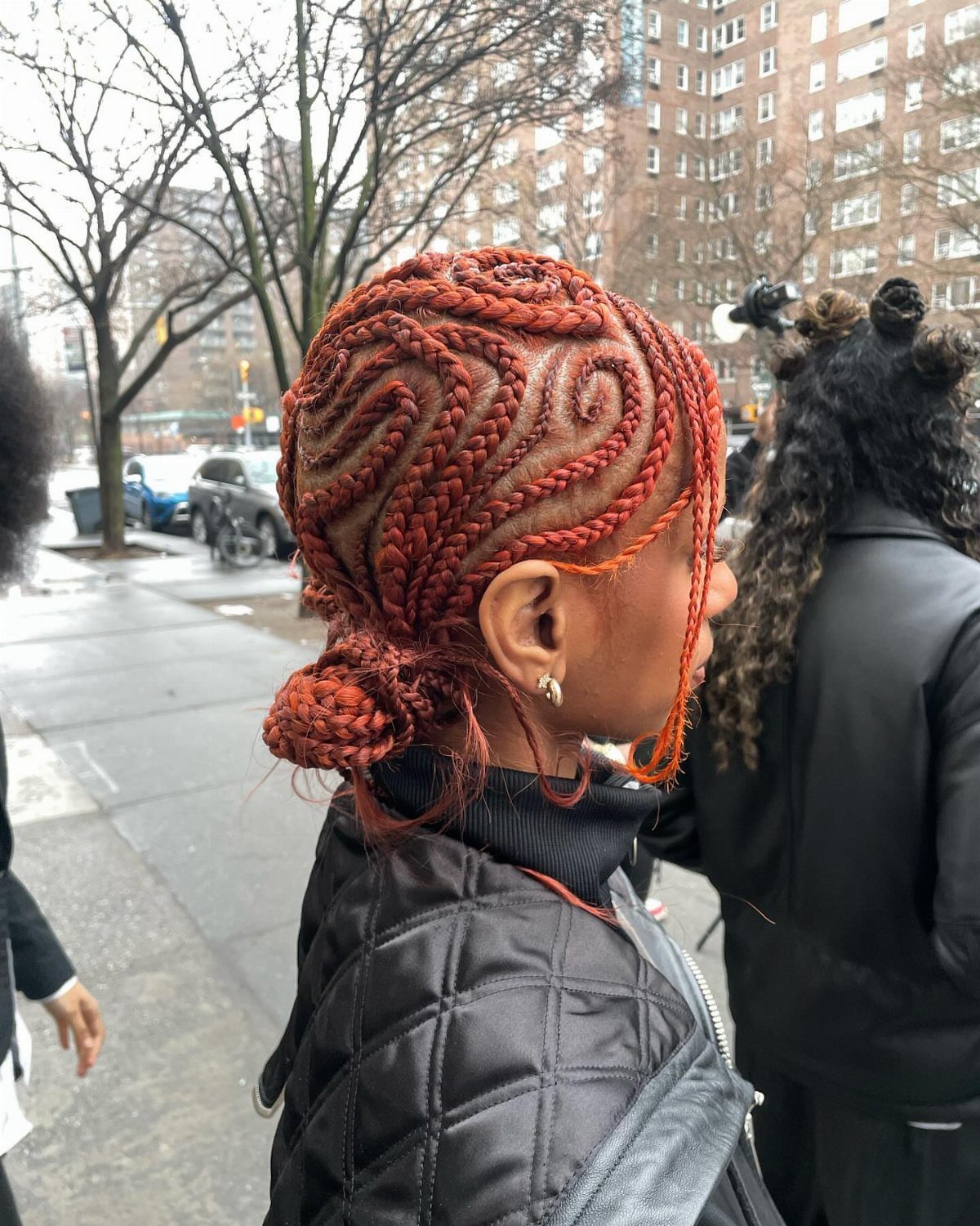 Cornrows and Twists Hairstyles: 11 Ideas to Try 8 Person with reddish-orange cornrows styled in curved patterns gathered into a low bun.