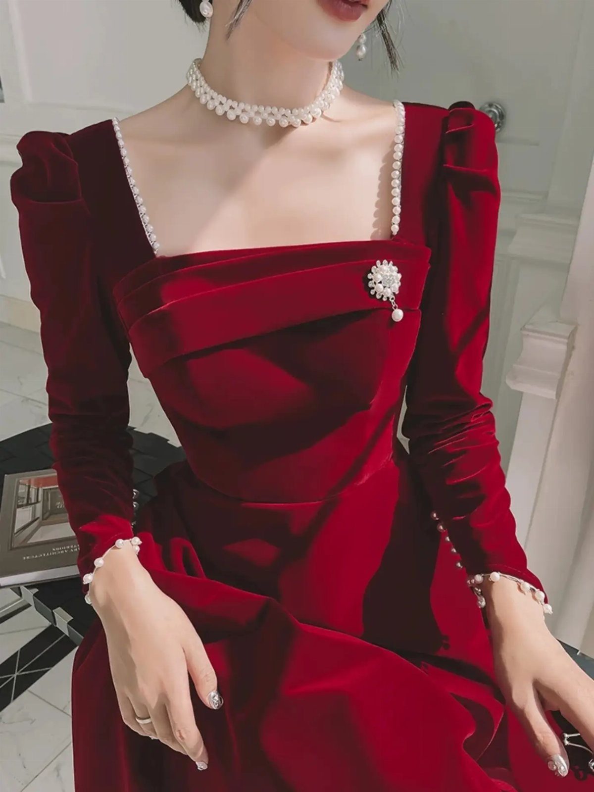 Deep red velvet dress with pearl trim and matching pearl jewelry accessories.