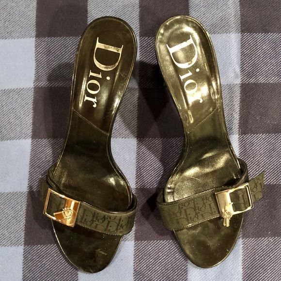 Black Dior monogram slide sandals with gold buckles on a checkered background