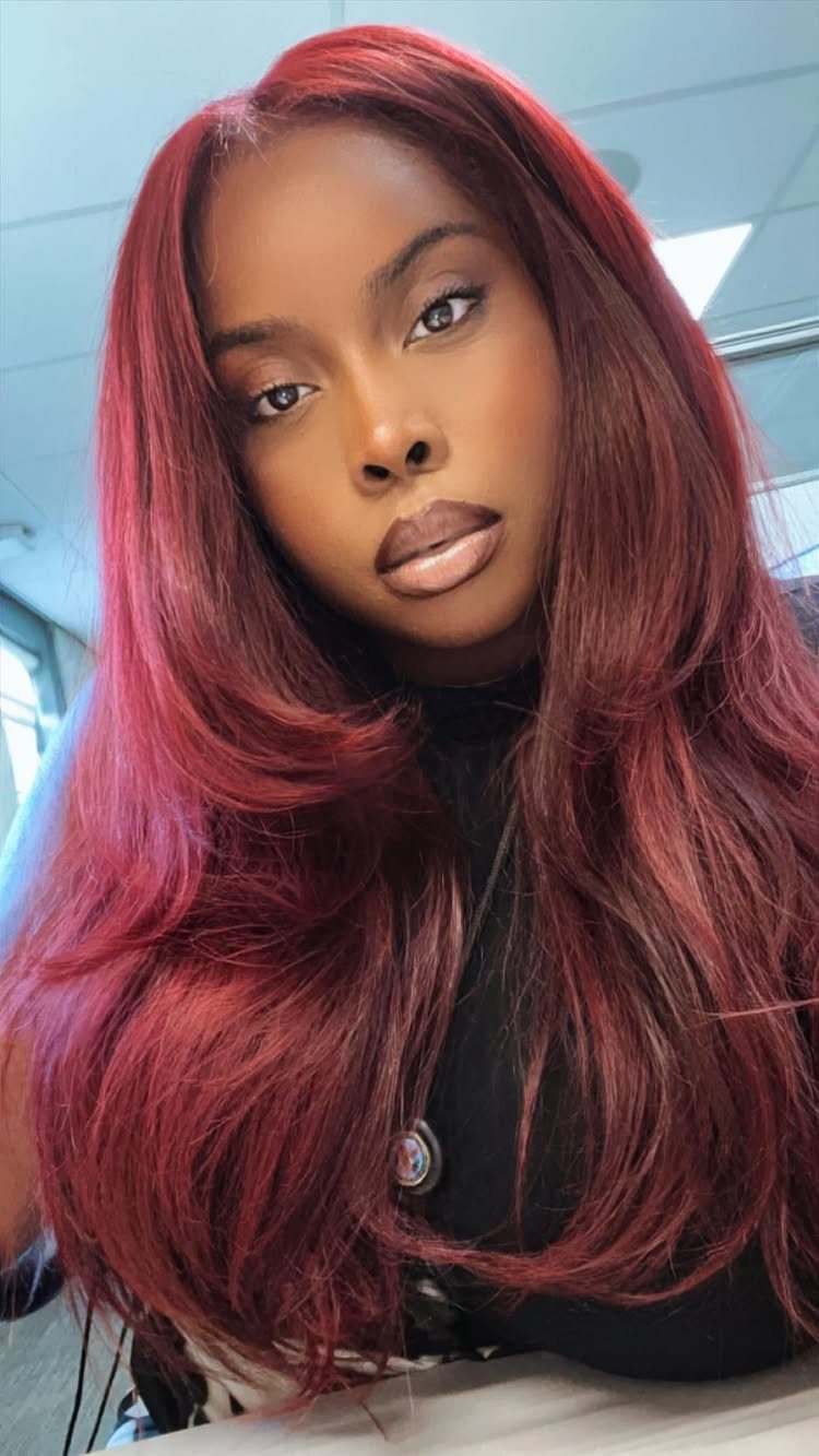 Different Shades of Red Hair Dye: 15 Looks, Copper to Crimson 3 Woman with long, vibrant cherry red hair posing for a close-up portrait.