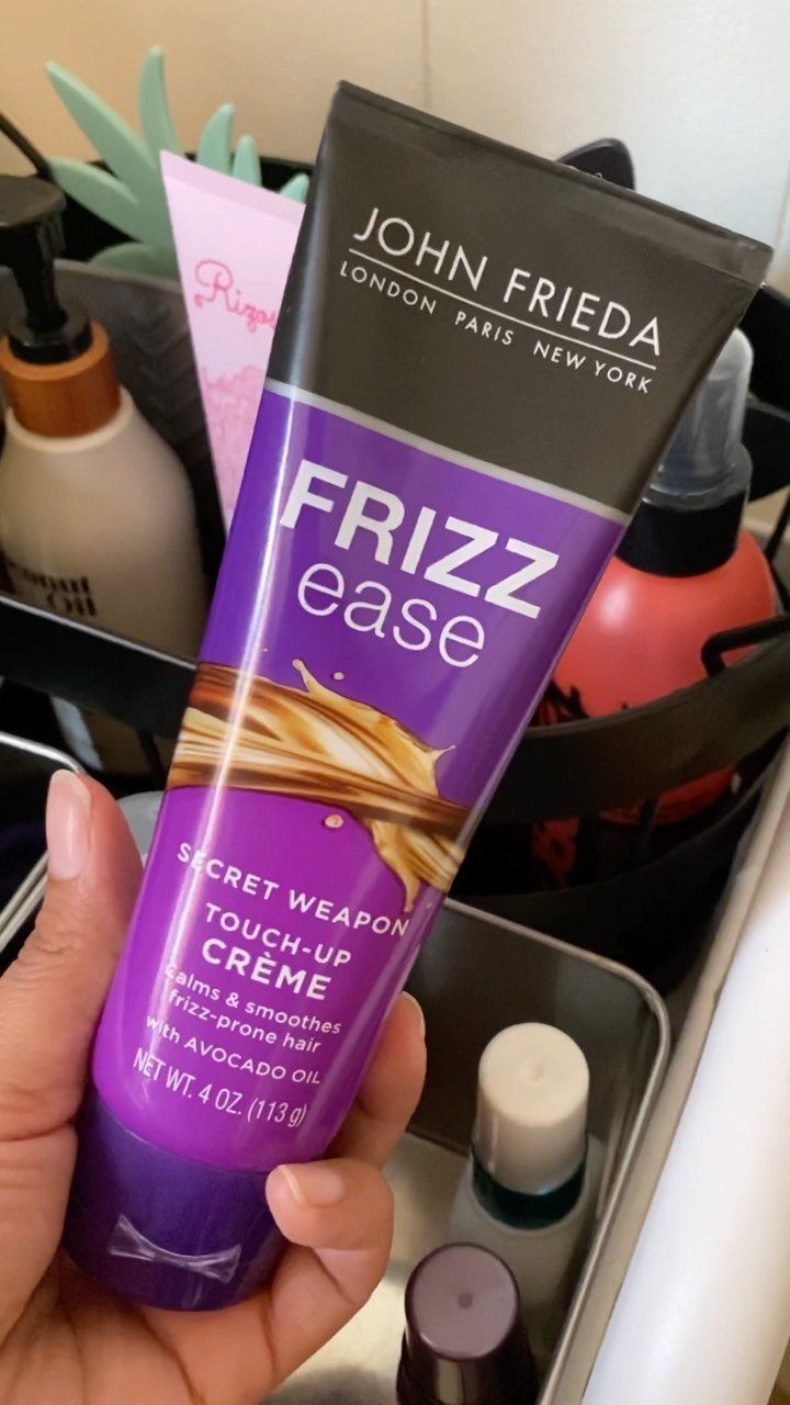 John Frieda Frizz Ease Touch-Up Crème tube held in a person's hand.