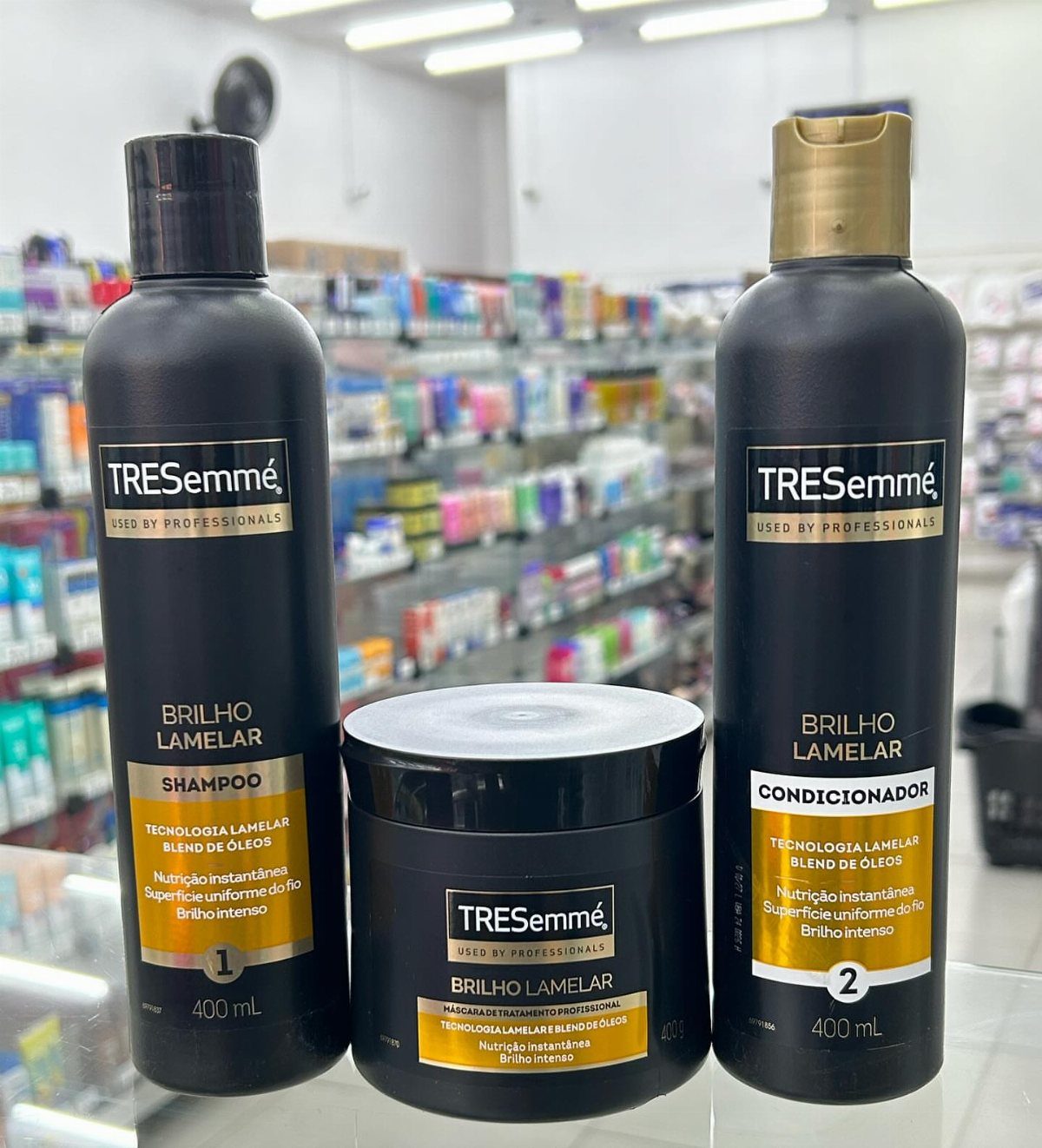 TRESemmé Brilho Lamelar shampoo, conditioner, and hair mask bottles on a store shelf