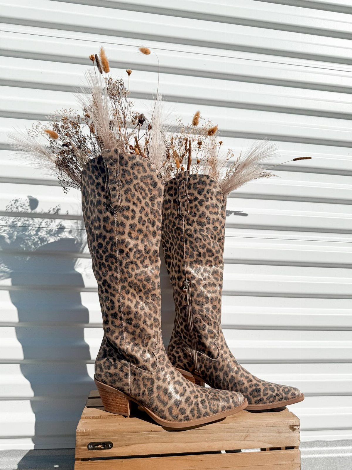 Fall Cowboy Boots for Women: 9 Ideas to Wear Now 4 Leopard print cowboy boots standing on a wooden crate with dried grass background