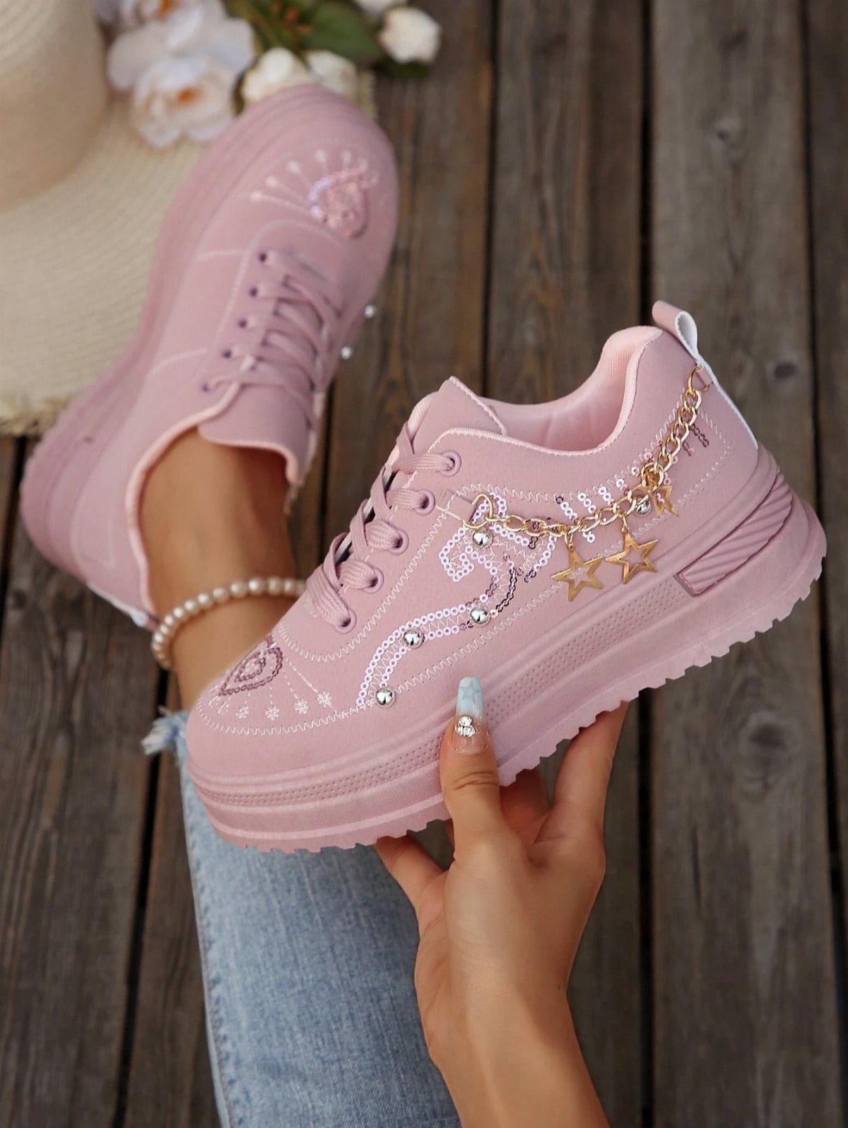 Fancy Sneakers for Women: 9 Ideas, From Retro to Platform 5 Pink chunky-sole sneakers with gold star accents paired with light blue cropped denim jeans.