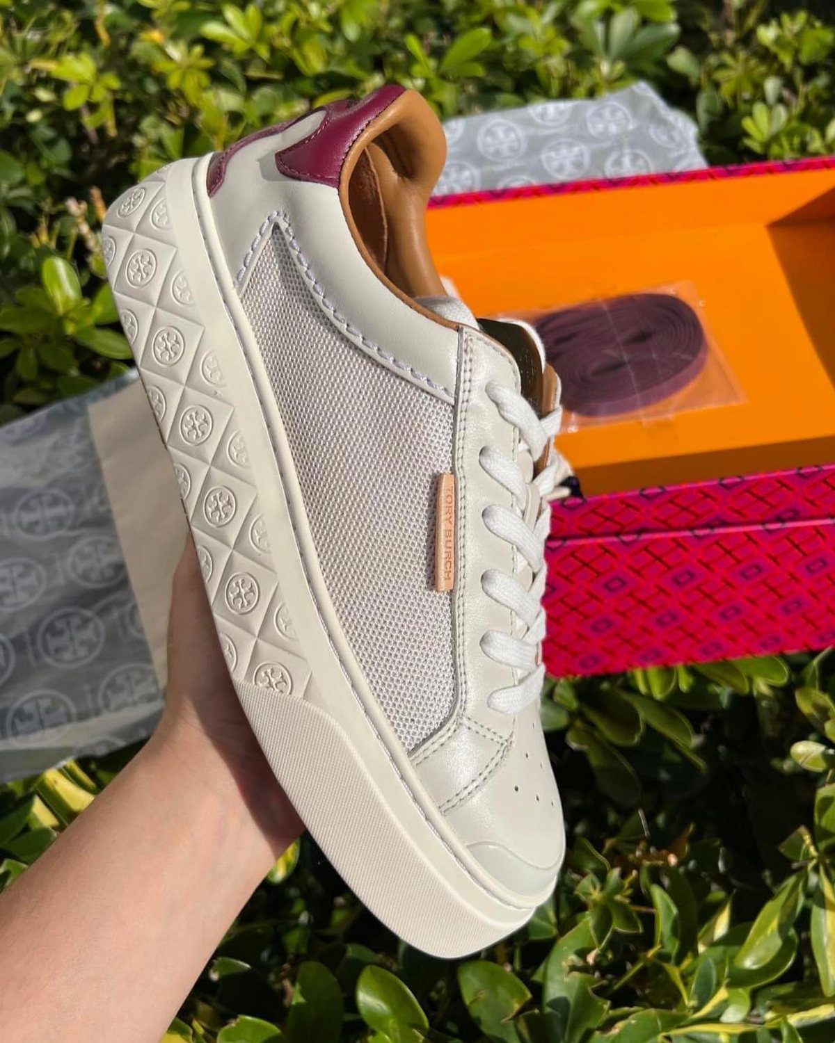 Fancy Sneakers for Women: 9 Ideas, From Retro to Platform 3 White leather and mesh sneaker with purple accents held against green leaves