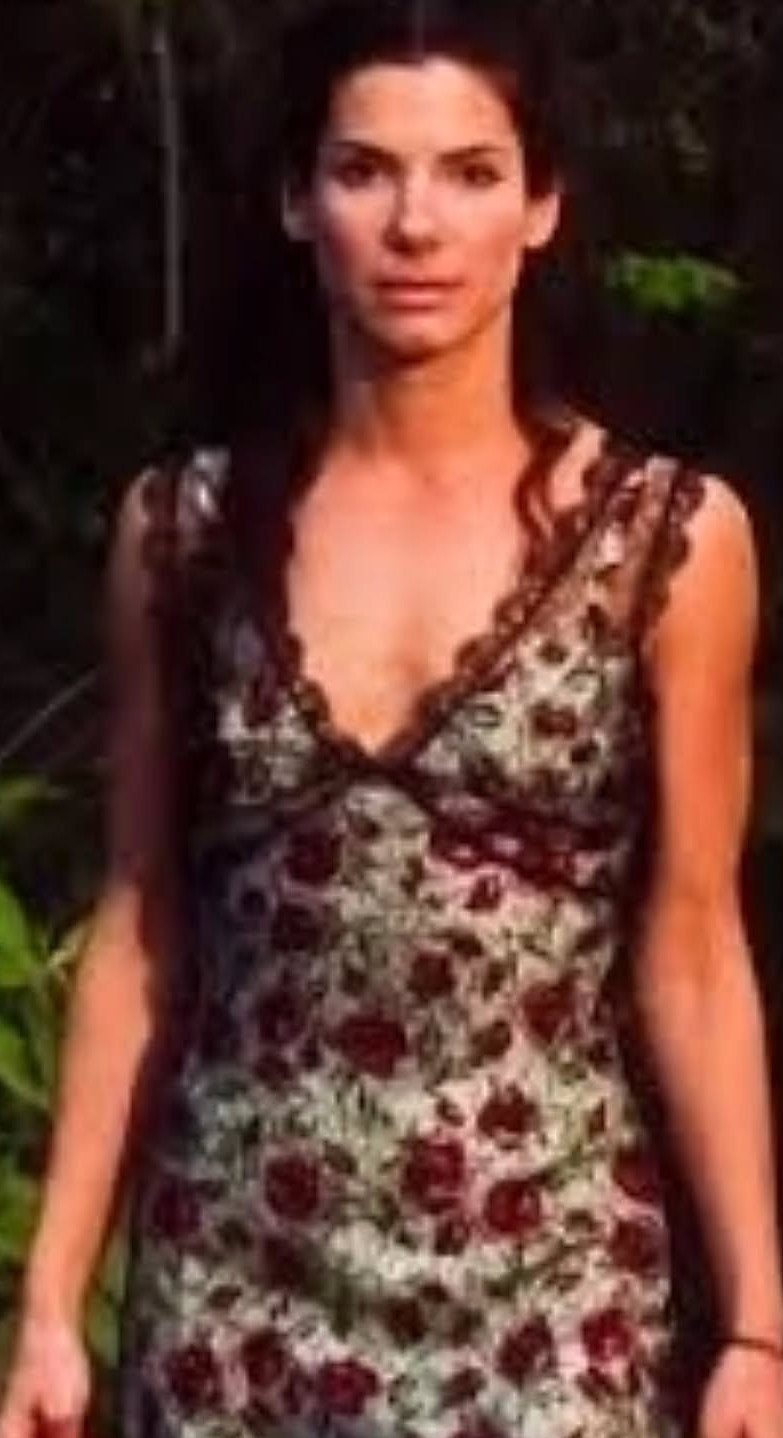 Gillian Practical Magic Outfits: 11 Ideas to Wear Now 3 Woman wearing a floral print slip dress with red flowers and lace trim.