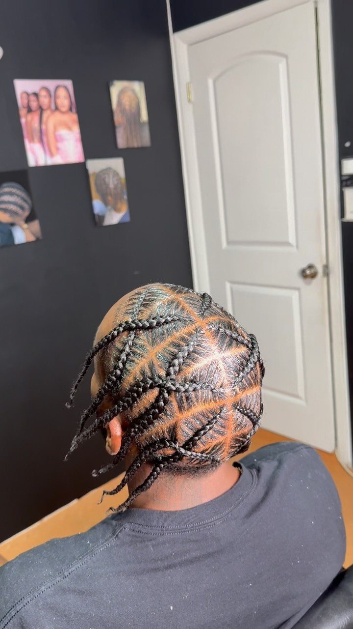 Man with black cornrows styled from the middle of his head.