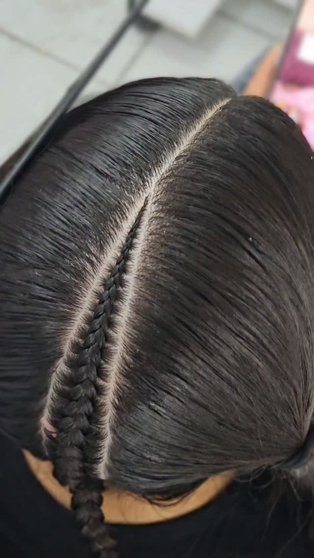 Dark hair with a single tight cornrow braid running down the center scalp.
