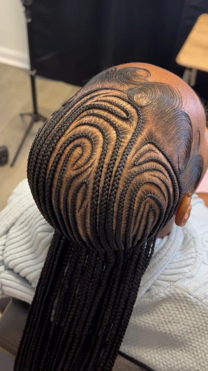 Intricate small cornrow braids in swirling patterns on a person's head.