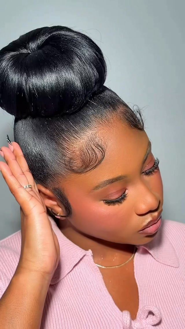 Hair Up Styles to Try: 12 Buns, Ponytails and More 6 Woman with a high, smooth, round ballerina bun and styled edges.