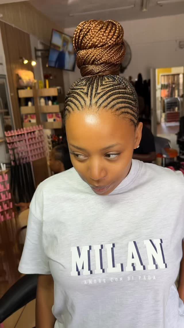 Hair Up Styles to Try: 12 Buns, Ponytails and More 9 Woman with brown braided hair styled into a high, neat top bun.