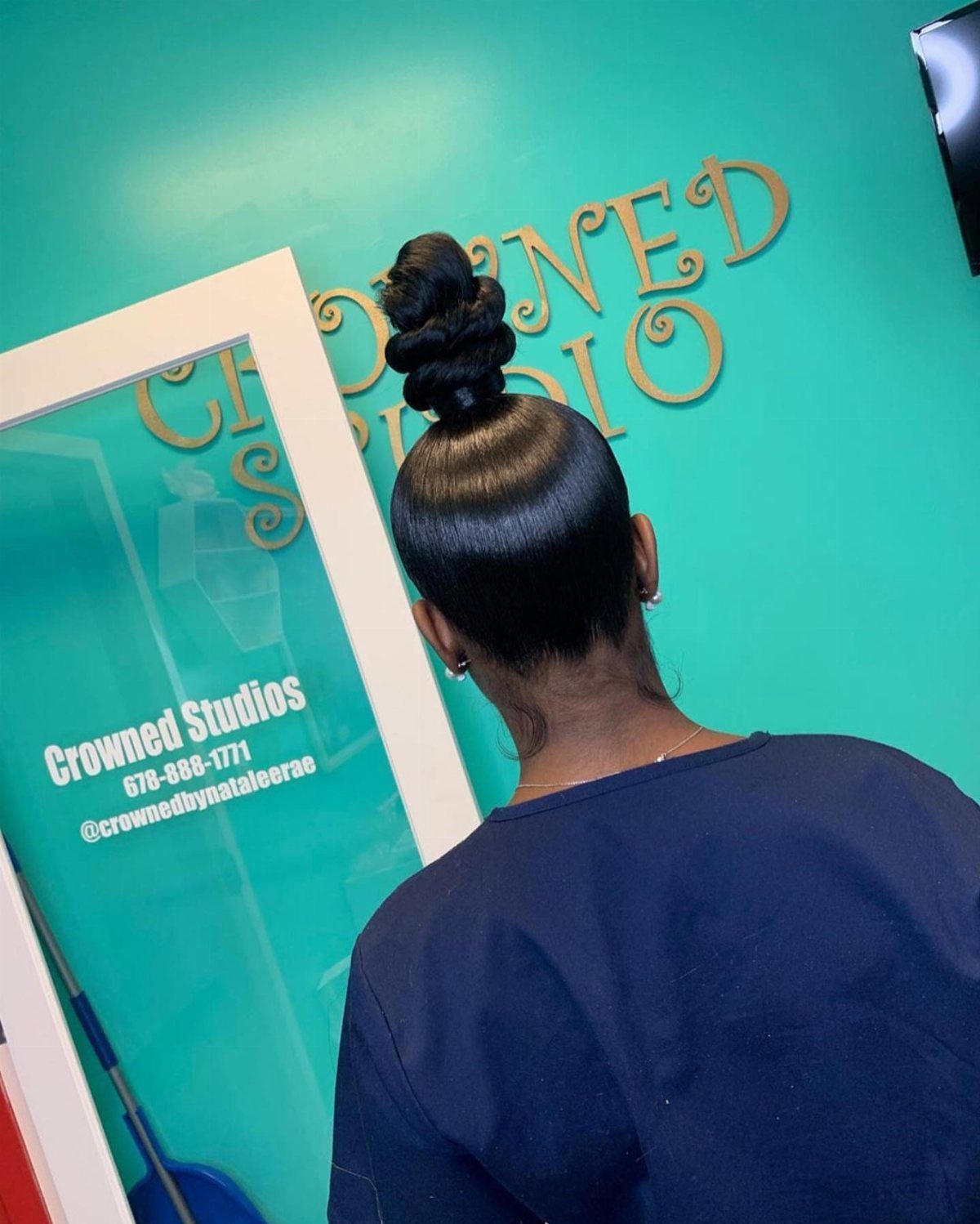 Hair Up Styles to Try: 12 Buns, Ponytails and More 4 Person with dark hair styled in a high twisted top knot bun.