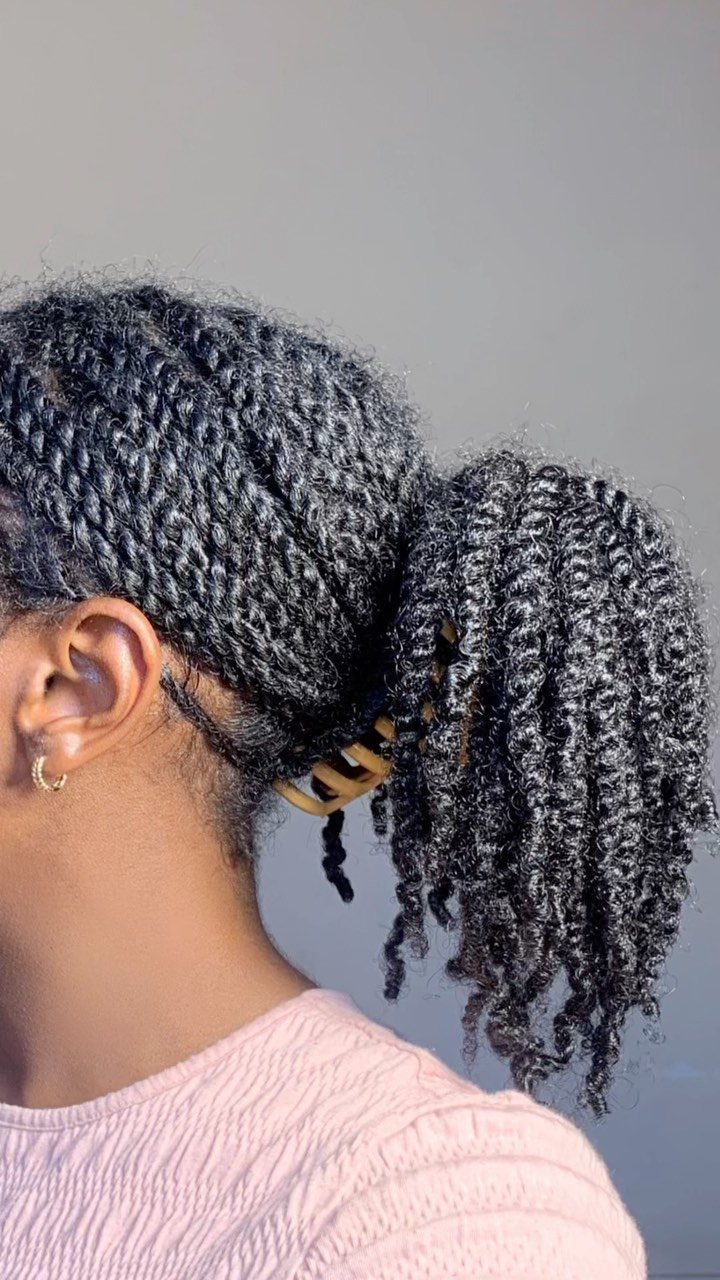 7 Hairstyle for Claw Clip Ideas, Messy Bun to Updo 5 Dark curly hair gathered in a low ponytail secured with a tan claw clip.