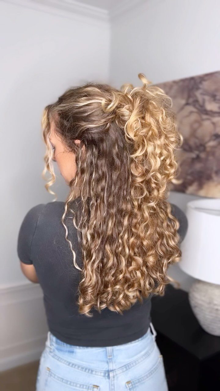 7 Hairstyles for Long Hair Down: Braids, Waves and Curls 2 Woman with long curly blonde hair styled in a half up half down bun.