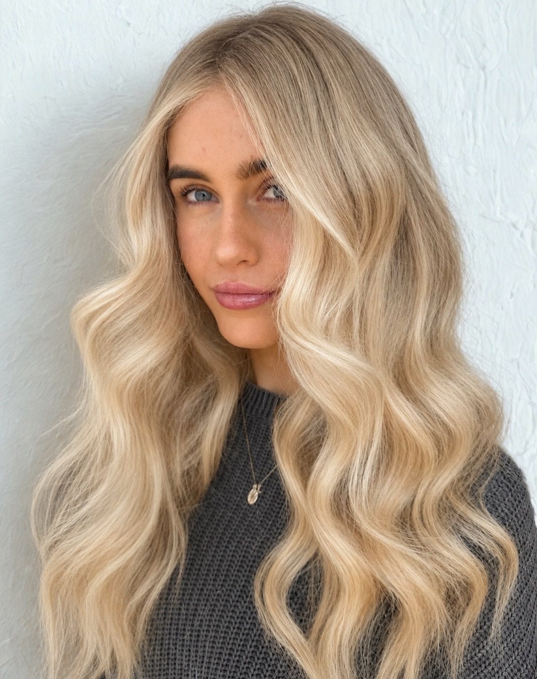 14 Hairstyles for Long Hair for Summer, Easy and Cool 6 Woman with long blonde hair styled in loose beach waves against white wall