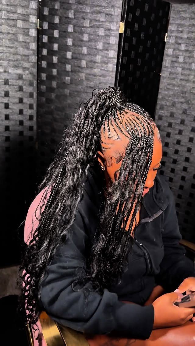 Person with long black curly hair in a braided high ponytail and curls.