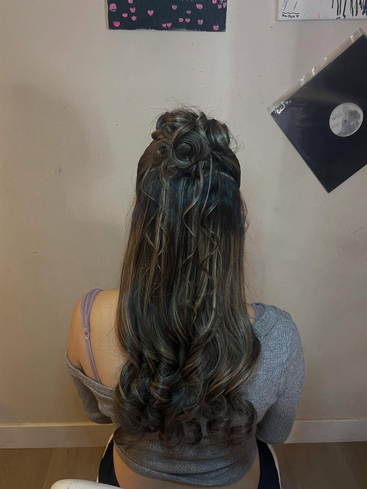Long brown curly hair styled in a half-up bun from behind