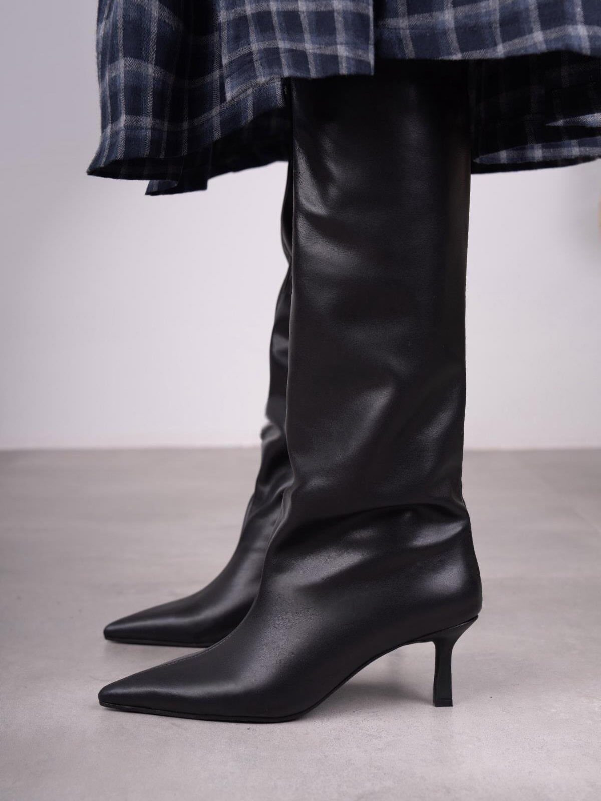 High Cut Boots: 13 Ideas from Kitten Heels to Thigh-High 1 Black leather knee-high boots with kitten heels and pointed toes worn with plaid skirt.