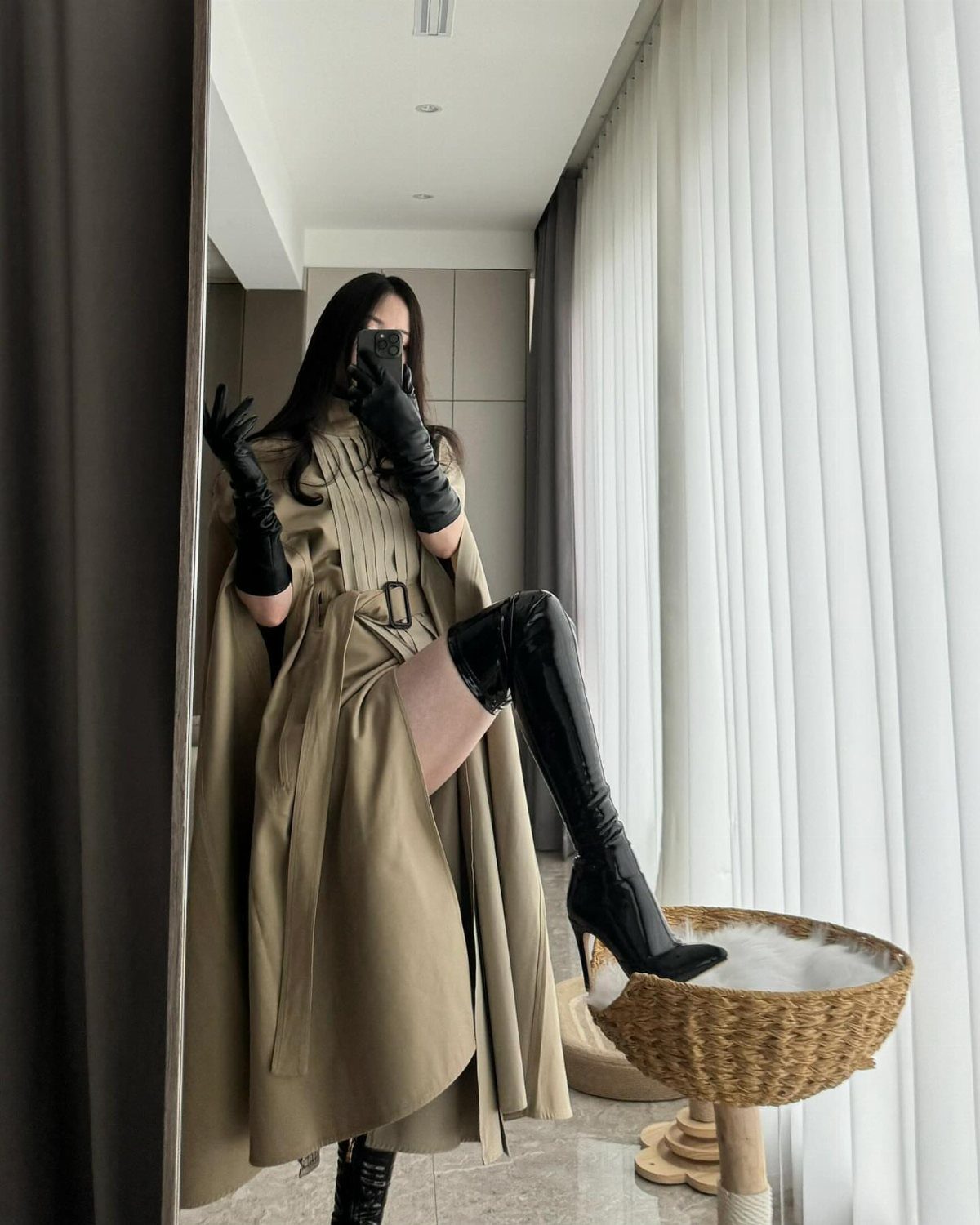 High Cut Boots: 13 Ideas from Kitten Heels to Thigh-High 6 Person in tan coat and black over-the-knee boots posing by white curtains.