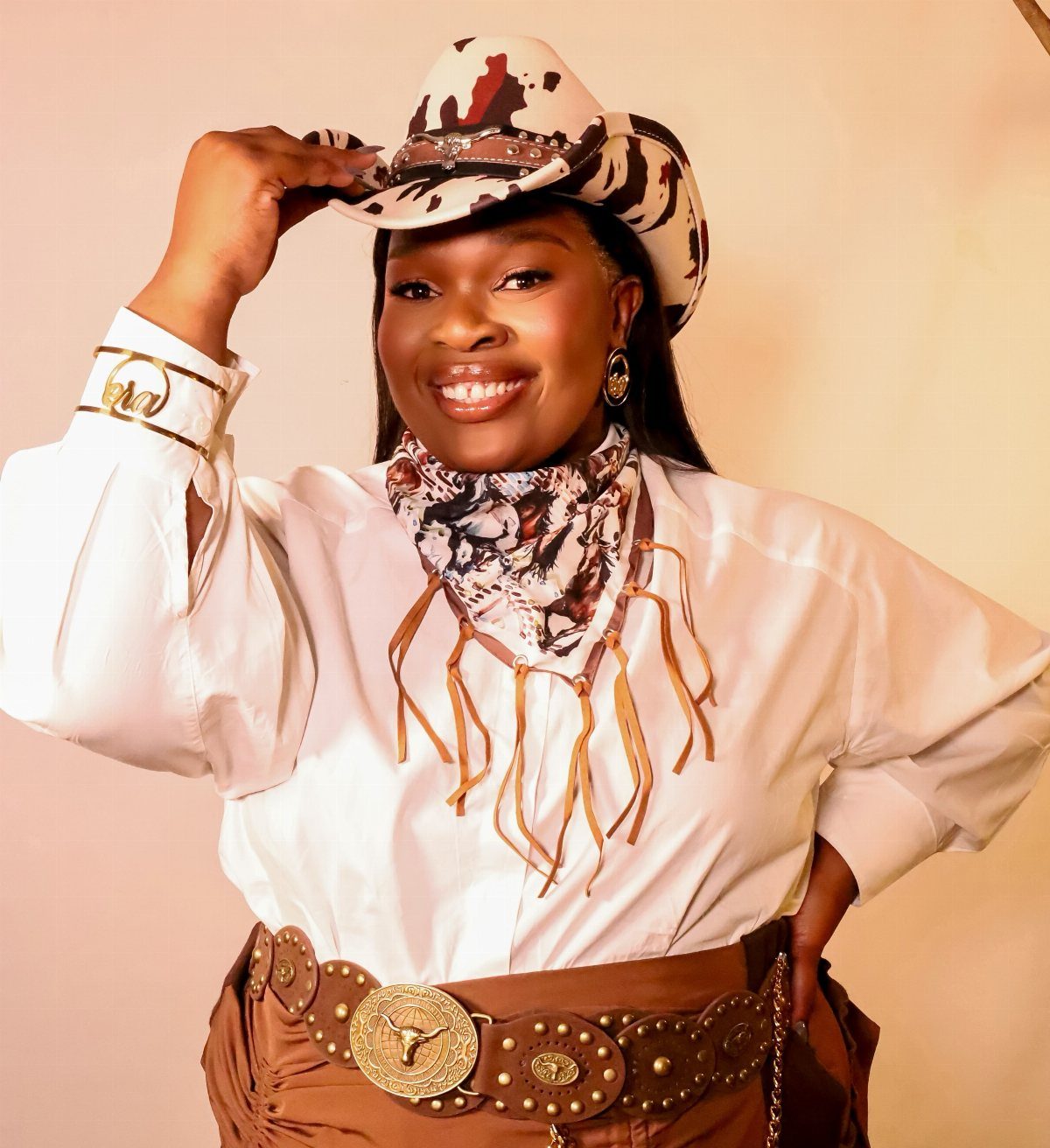 11 Hoedown Outfit Ideas for Boots, Denim and Dresses 9 Woman in western attire wearing a patterned cowboy hat and ornate leather belt.
