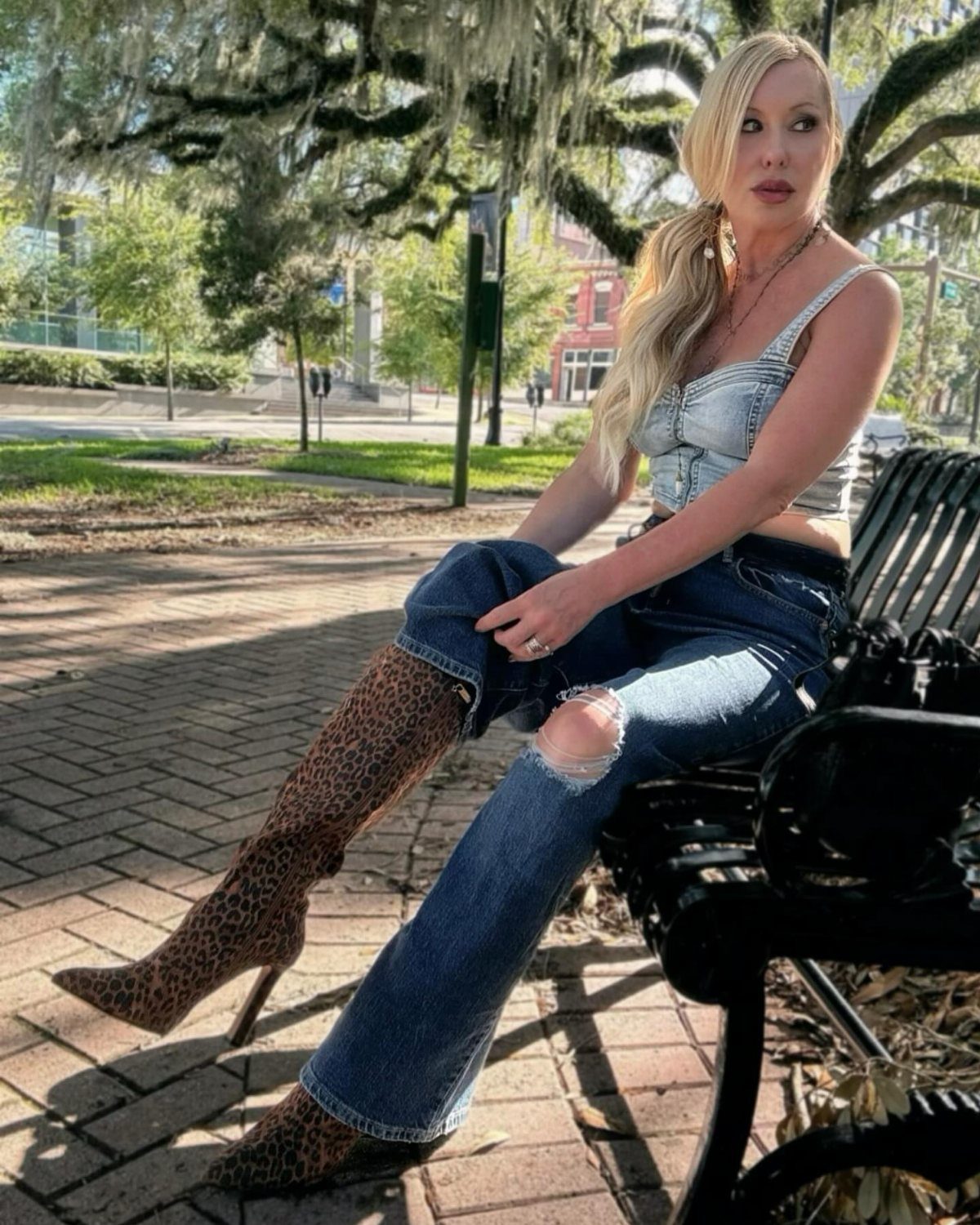 11 Hoedown Outfit Ideas for Boots, Denim and Dresses 3 Blonde woman in denim crop top and leopard print boots sitting on bench