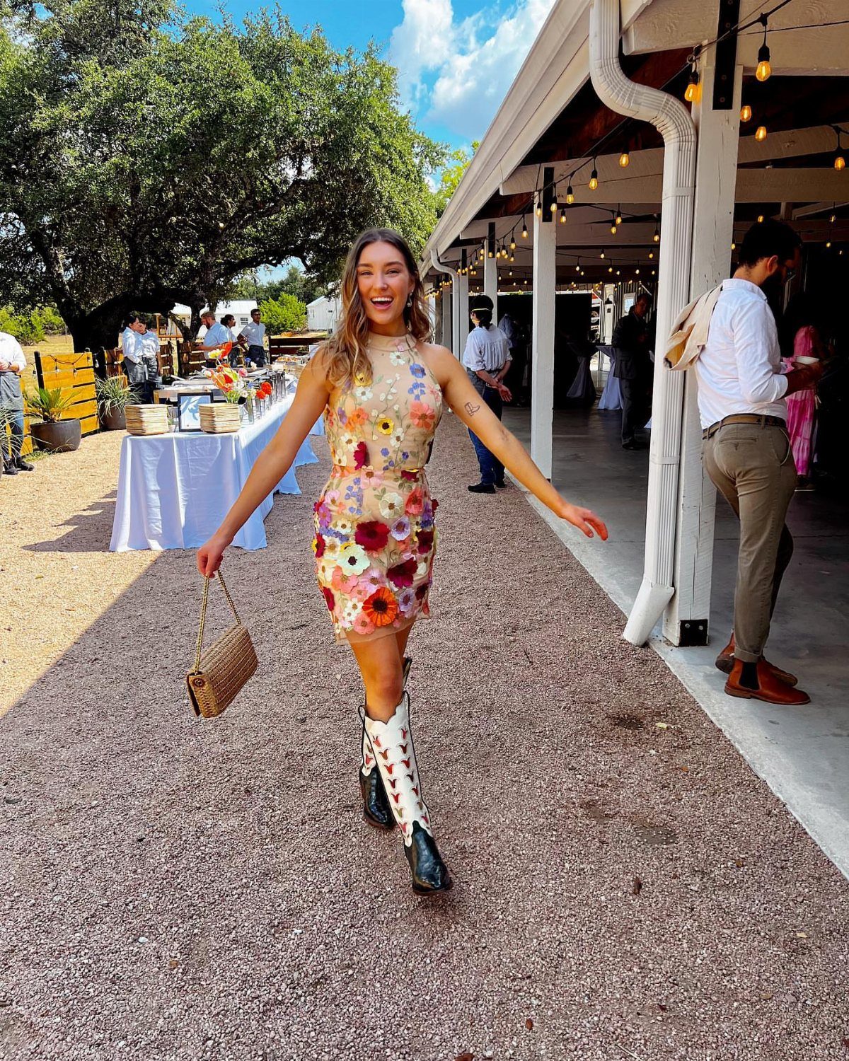 11 Hoedown Outfit Ideas for Boots, Denim and Dresses 8 Woman in a floral dress and white cowboy boots posing outdoors at a party