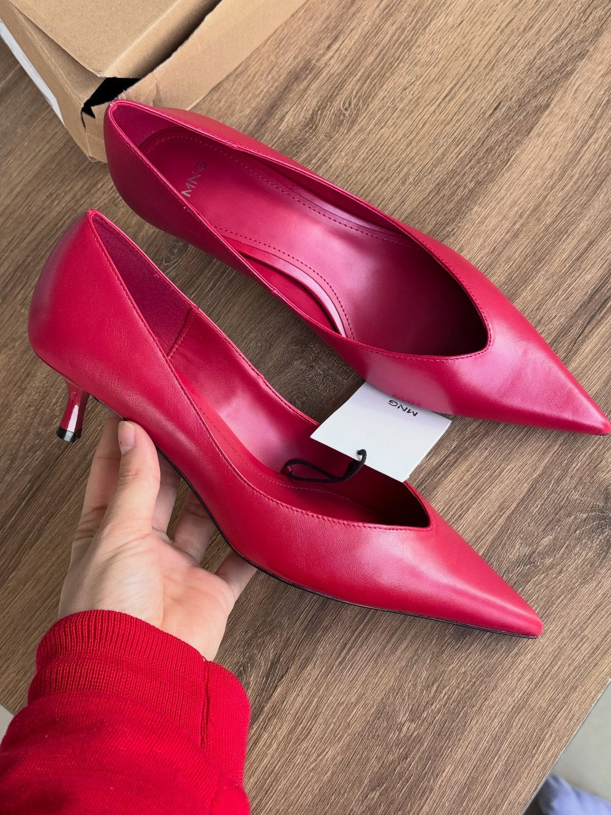 Kitten Heel Shoes for Women: 10 Ideas and Outfits 9 Red pointed-toe kitten heel pumps resting on a wooden table with a price tag.