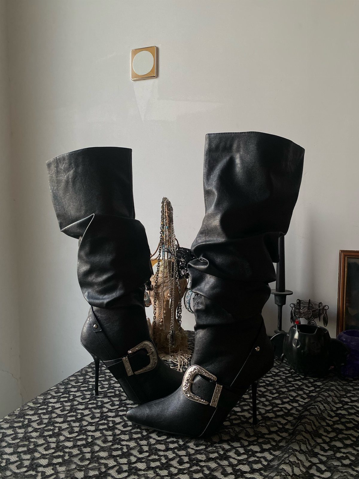 8 Leather High Heel Boots Ideas for Every Outfit 7 Black leather high heel boots with silver buckles on a leopard print surface