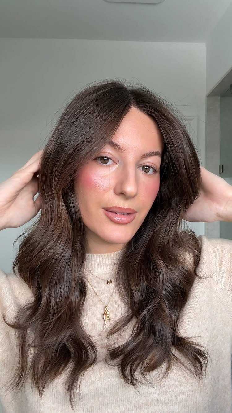 Level 2 Hair Ideas: 5 Looks for Dark Brown Bases 1 Woman with long dark brown hair styled in soft, voluminous loose waves.