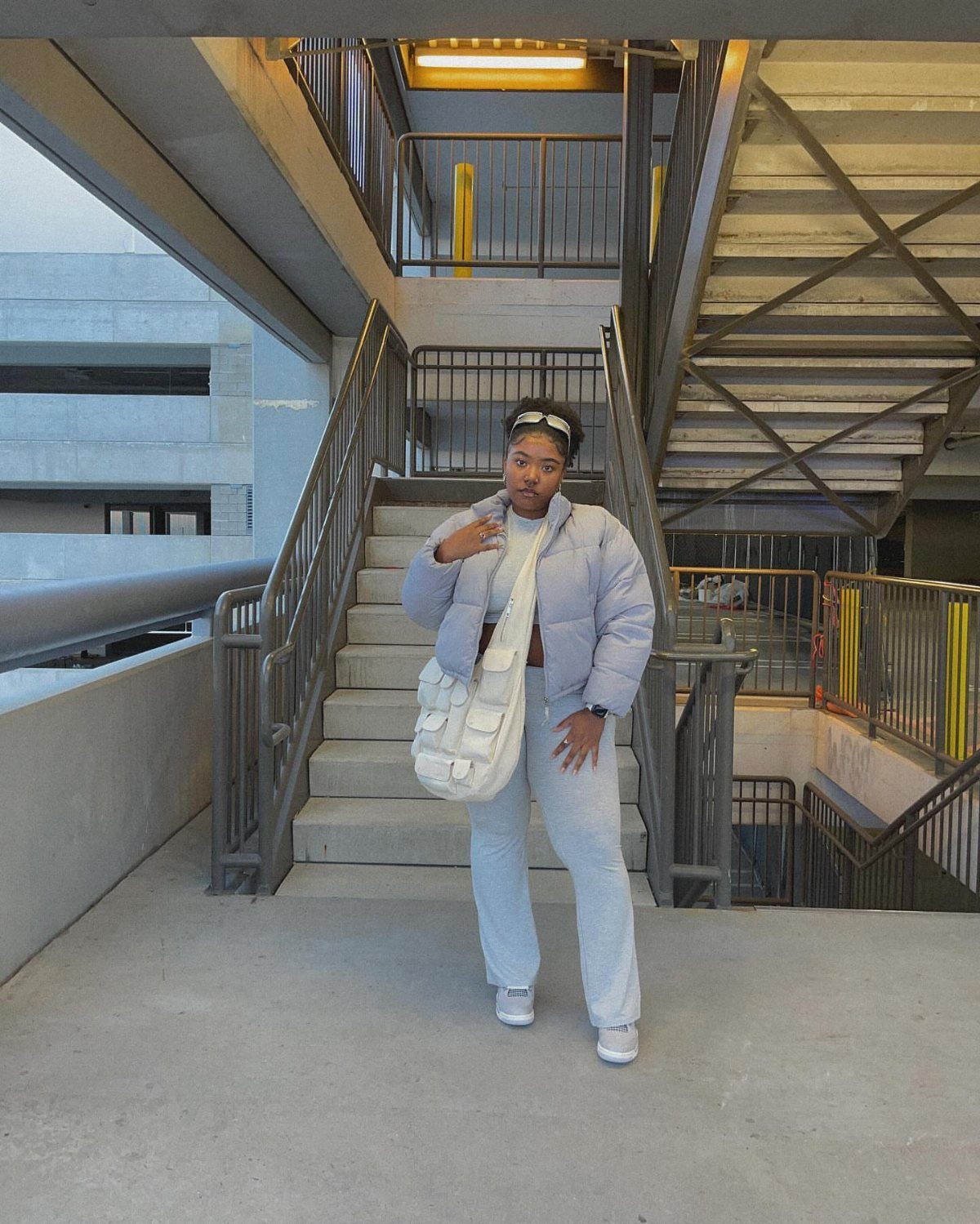 Light Grey Dunks: 5 Ideas, From Smoke Grey to Gum Soles 1 Person in light blue puffer jacket and grey pants posing by concrete stairs.