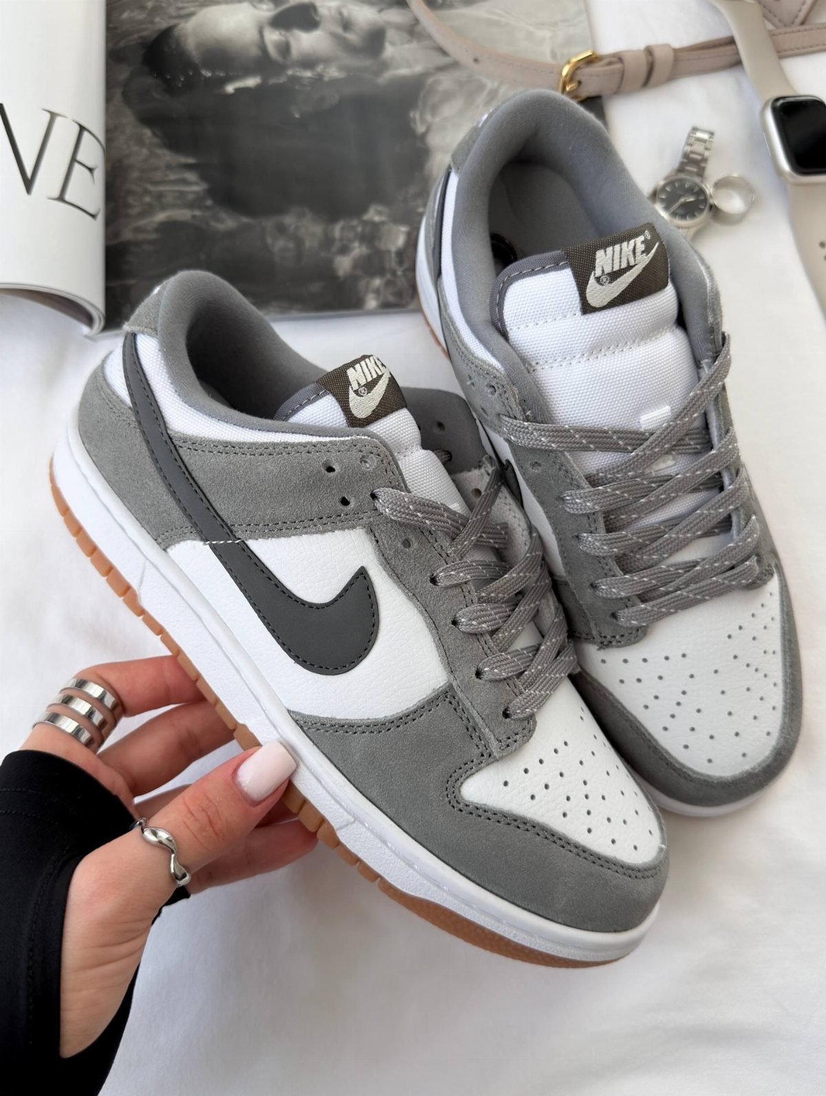 Light Grey Dunks: 5 Ideas, From Smoke Grey to Gum Soles 5 Light grey and white Nike Dunk sneakers with gum soles held by a hand.