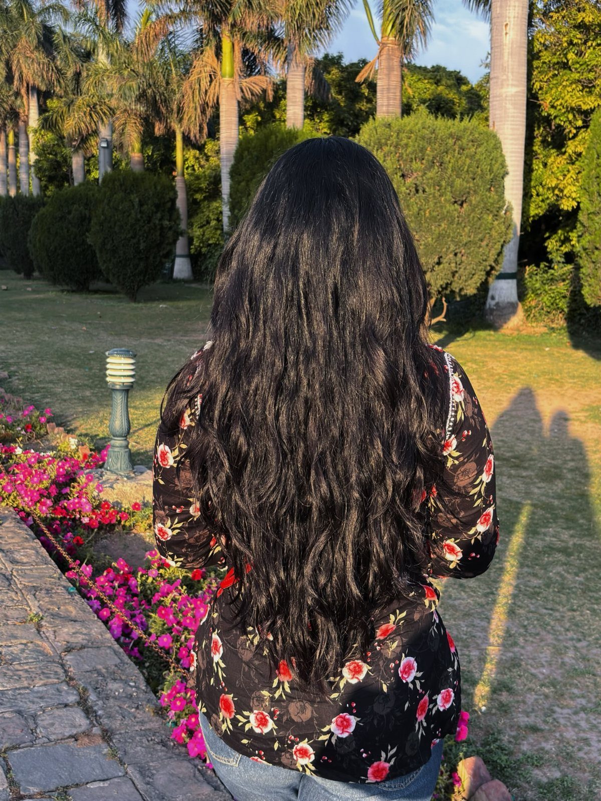 Long Russian Hair Ideas: 8 Looks, Colors and Textures 2 Long wavy black hair on a person standing in a sunny tropical garden