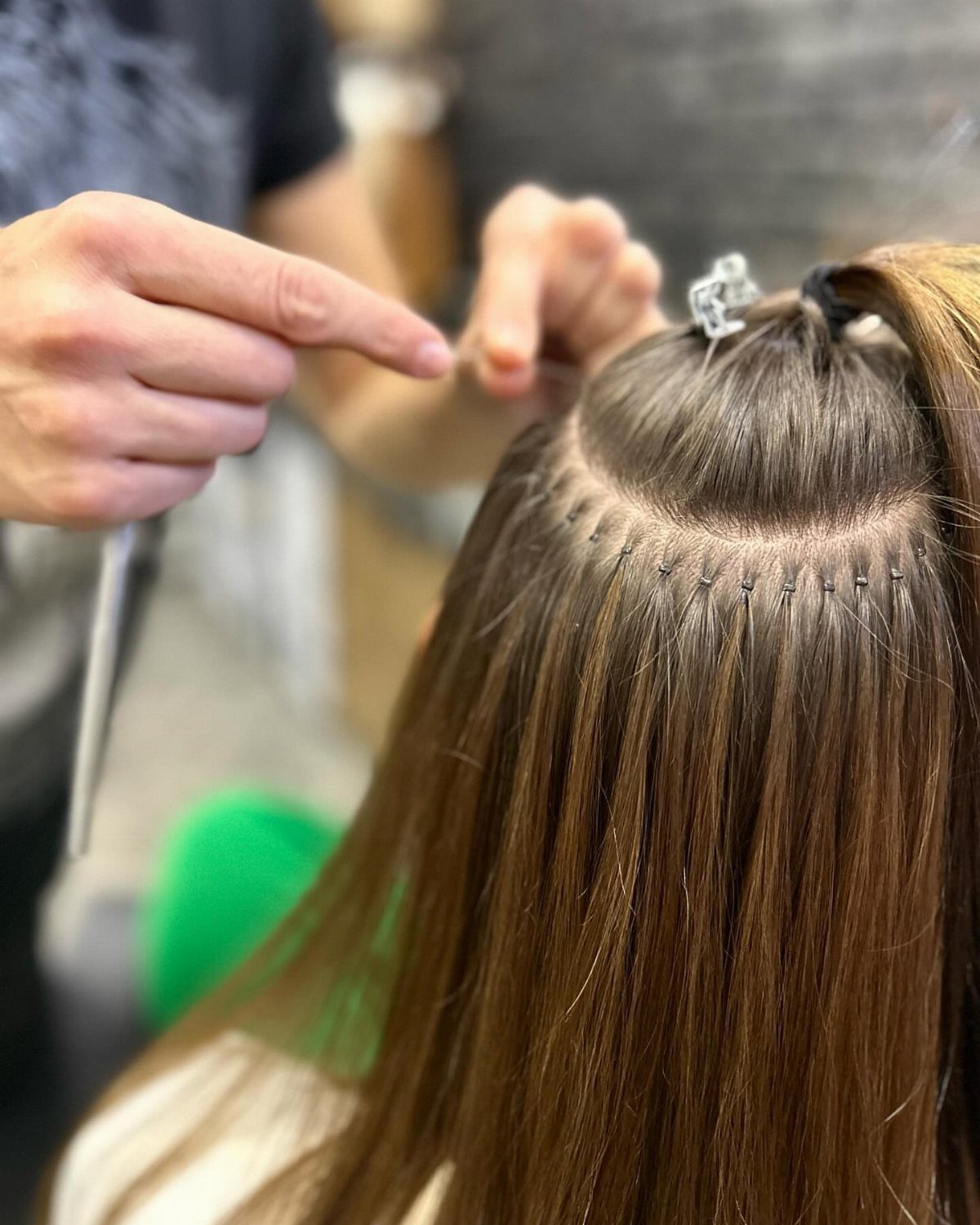 Long Russian Hair Ideas: 8 Looks, Colors and Textures 3 Brown hair extensions being installed with small metal micro-rings at the scalp.