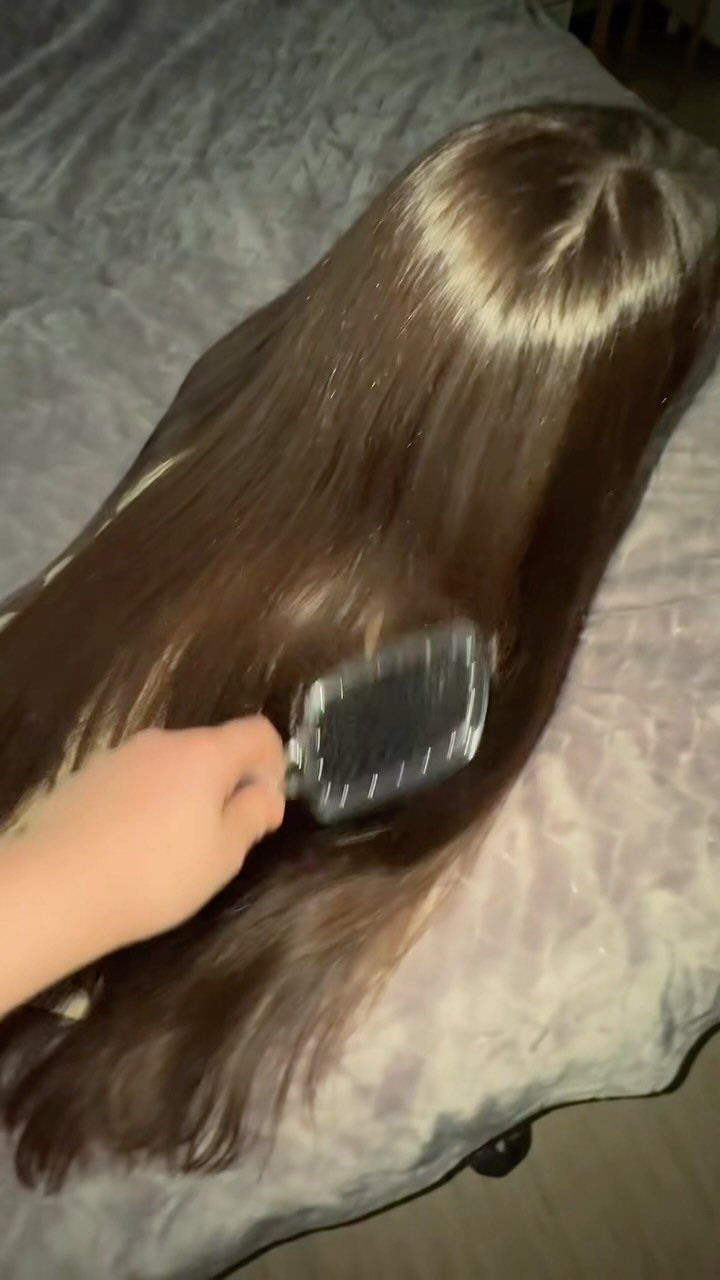 7 Ways to Make Hair Grow Faster, From Biotin to Microneedling 7 Long straight brown hair being brushed with a black paddle brush on grey fabric
