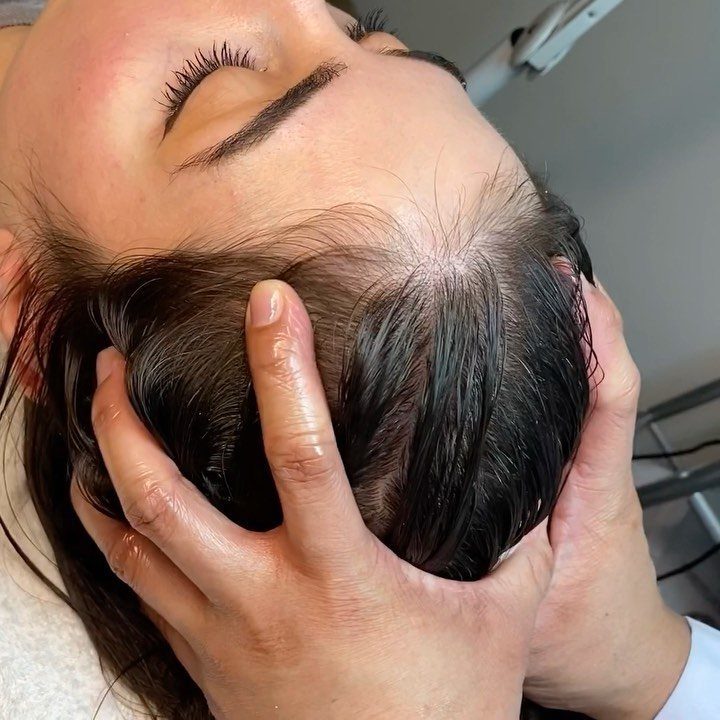 7 Ways to Make Hair Grow Faster, From Biotin to Microneedling 4 Hands massaging a person's scalp to stimulate hair growth in a salon setting