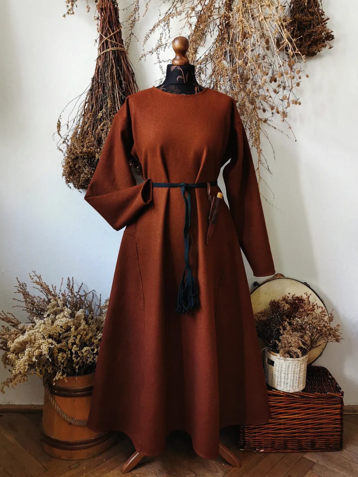 Brown wool medieval dress on a mannequin with a blue waist cord.